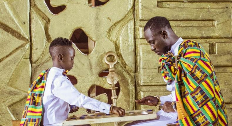 Okyeame Kwame play draughts with son