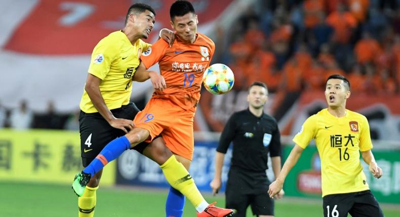 Song Wenjie (C) of Shandong Luneng competes for the ball with Tyias Browning (L) of Guangzhou Evergrande. Evergrande shaded their Chinese rivals 6-5 on penalties