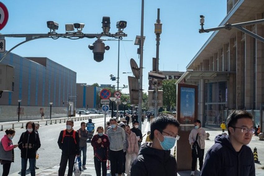 Ljudi prolaze ispod bezbednosnih kamera u Pekingu