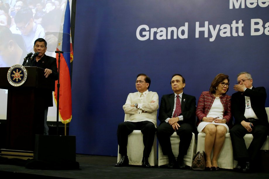 Philippine President Rodrigo Duterte, left, speaks during a meeting with members of the Filipino community at a hotel in Beijing, China, October 19, 2016.