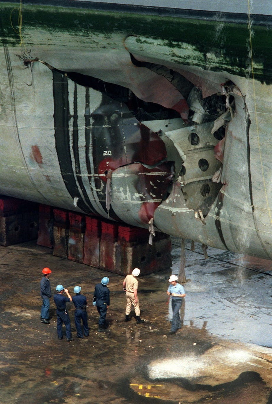 Ekipy naprawcze dokonują inspekcji amfibii szturmowej USS Tripoli po tym, jak uderzyła w iracką minę w Zatoce Perskiej 18 lutego 1991 r. 