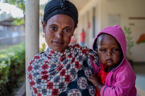 Alami na dziedzińcu szpitala św. Łukasza w Waliso. Dziewczynka najlepiej czuje się przytulona do matki i niemal nie odstępuje jej na krok