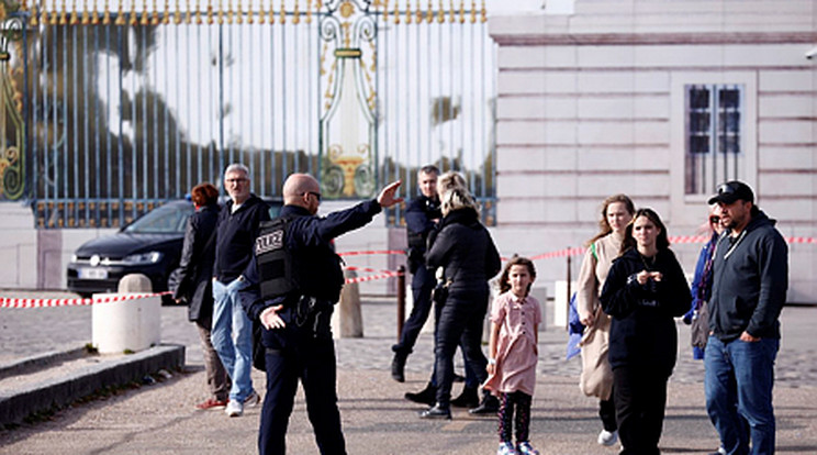 A versailles-i kastély bejáratát őrző francia rendőr turistákat tájékoztat 2023. október 17-én, miután biztonsági okból kiürítették a turistalátványosságot / Fotó: MTI/EPA/Yoan Valat