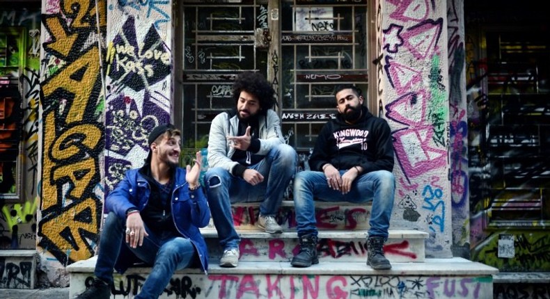 Syrian refugees from Aleppo (from L) Abu Habib, 24, Majd Ahmad, 26, and Abu Rmosh, 30, seen at the 'alternative' neighborhood of Exarchia in Athens, home to many Syrian refugees in NGO-leased apartments or in squats run by anarchist movements