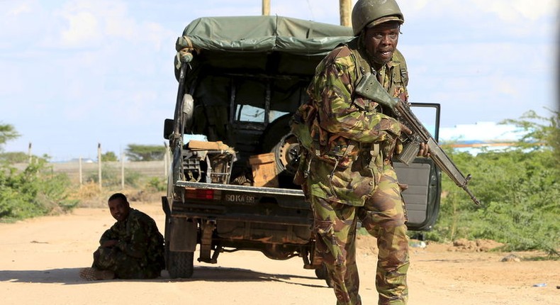 A Kenya Defense Force soldier runs for cover near the perimeter wall where attackers are holding up at a campus in Garissa April 2, 2015. REUTERS/Noor Khamis