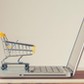 Small Shopping Cart On Laptop With Copyspace : Online Shopping Concept. E-commerce.