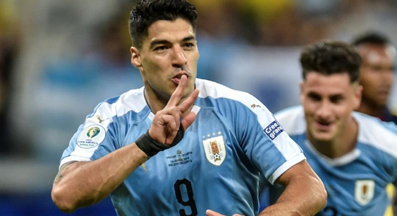 Luis Suarez wheels away in celebration after netting Uruguay's third goal following a flick-on by Martin Caceres