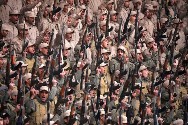 Fighters from the self-defence forces of the Kurdish-led north hold their weapons during a rally in 