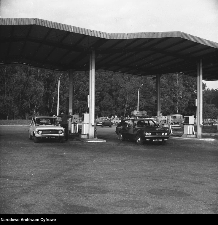Stacja paliw w Hucie Zawadzkiej (dzisiejsze województwo łódzkie), przełom lat 70. i 80. XX w. Proszę zwrócić uwagę na kolejkę.