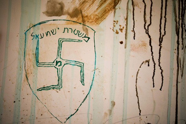 A swastika and text in Hebrew reading Israeli police are seen on a wall of a synagogue after it wa