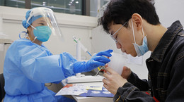 Mężczyzna przyjmuje wziewną szczepionkę przypominającą. 26 października 2022 r., Szanghaj, Chiny