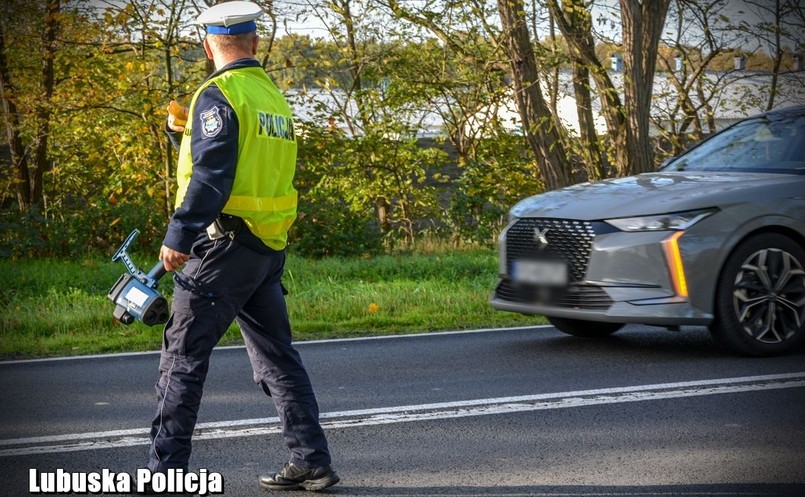 Policjant z miernikiem zatrzymuje kierowcę za przekroczenie prędkości