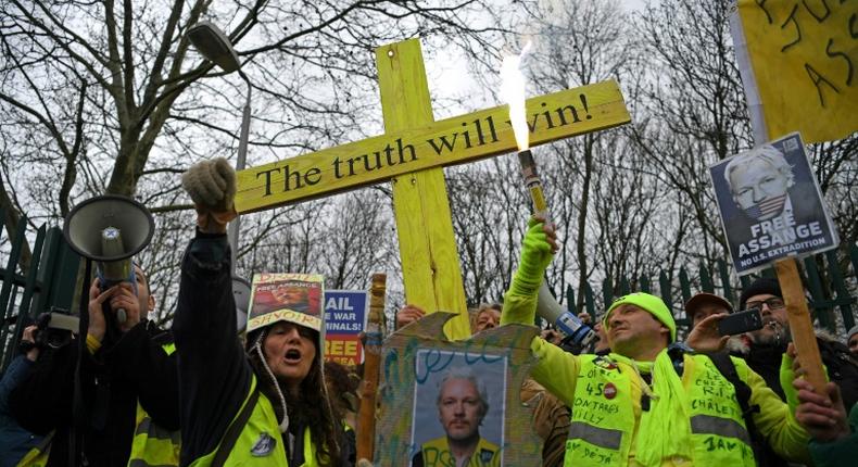 A supporter of WikiLeaks founder Julian Assange outside his US extradition hearing in London where his lawyer said he had been stripped naked and handcuffed several times by prison officers during the process