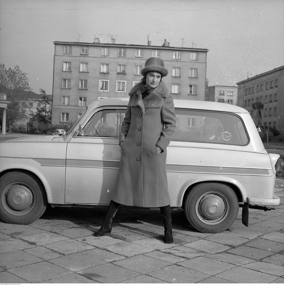 Pokaz kolekcji Domu Mody "Ambasador" na ulicy Nowolipie w Warszawie. Modelka w palcie z futrzanym kołnierzem. W tle samochód Trabant 600, 1967 - 1974 r. Autor: Rutowska Grażyna, NAC