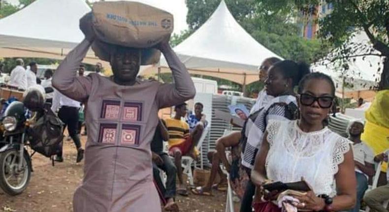 Captain Smart carrying a bag of cement