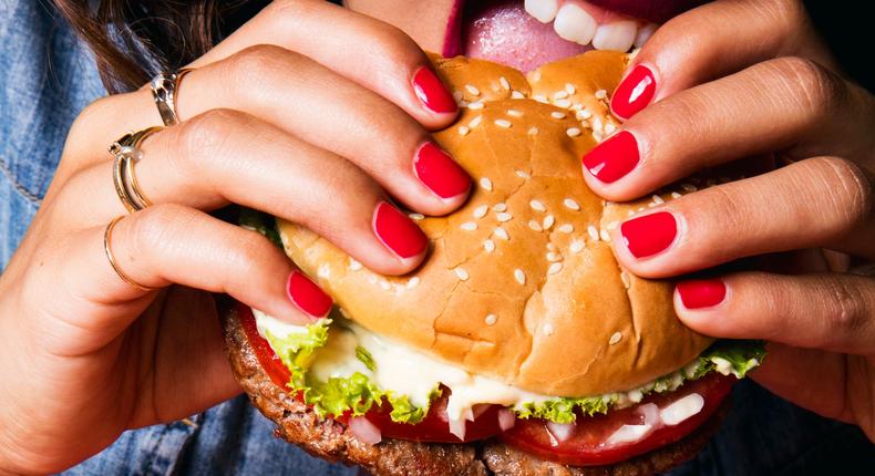 impossible burger woman eating hands red nails