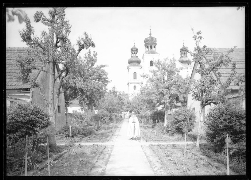 Zakonnik w ogrodzie, obok budynki przy kościele i klasztorze Kamedułów. 1934 r. Fot. Narodowe Archiwum Cyfrowe.