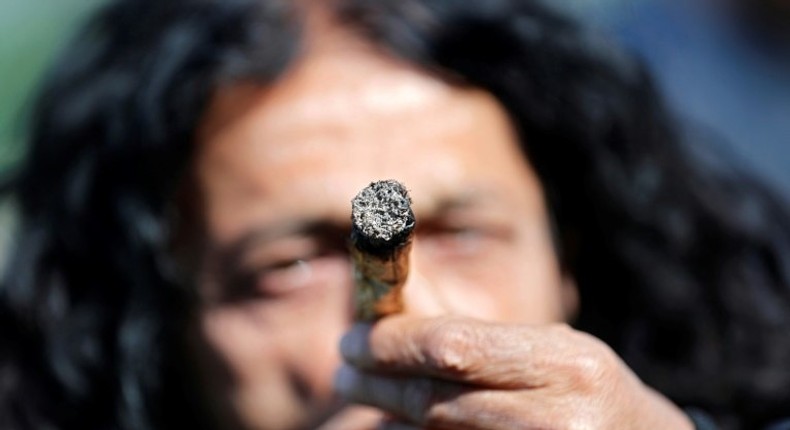 An Israeli smokes a marijuana joint in Jerusalem on April 20, 2017 during a rally to express their defiance of current laws