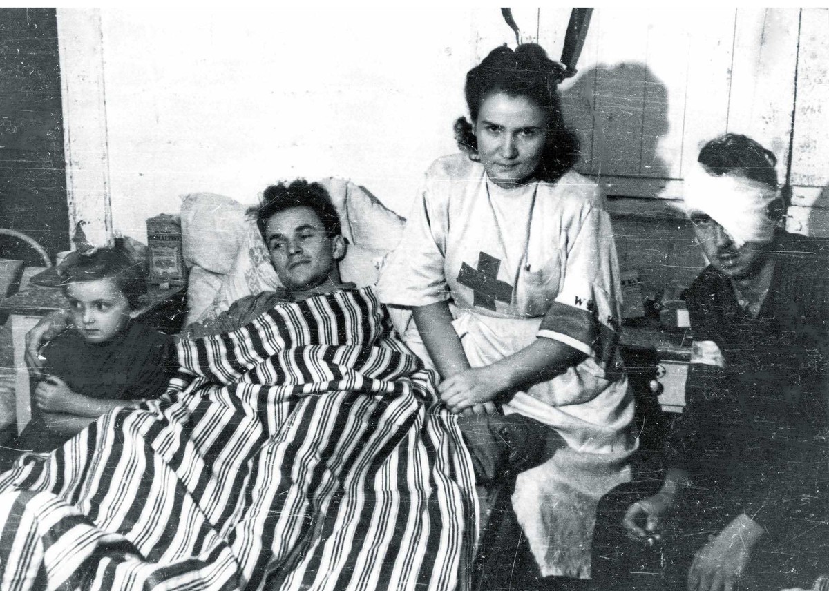 Pielęgniarka Janina Steczniewska „Inka” z córką i rannymi powstańcami w szpitalu kompanii „Koszta”. Sierpień 1944 r.