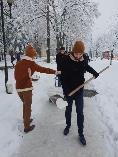 FOTO/ Studenții au ieșit să deszăpezească un trotuar de pe un bulevard din Timișoara pentru că s-au săturat să aștepte Primăria. Robu spune că s-a făcut "tot ce era omenește posibil"