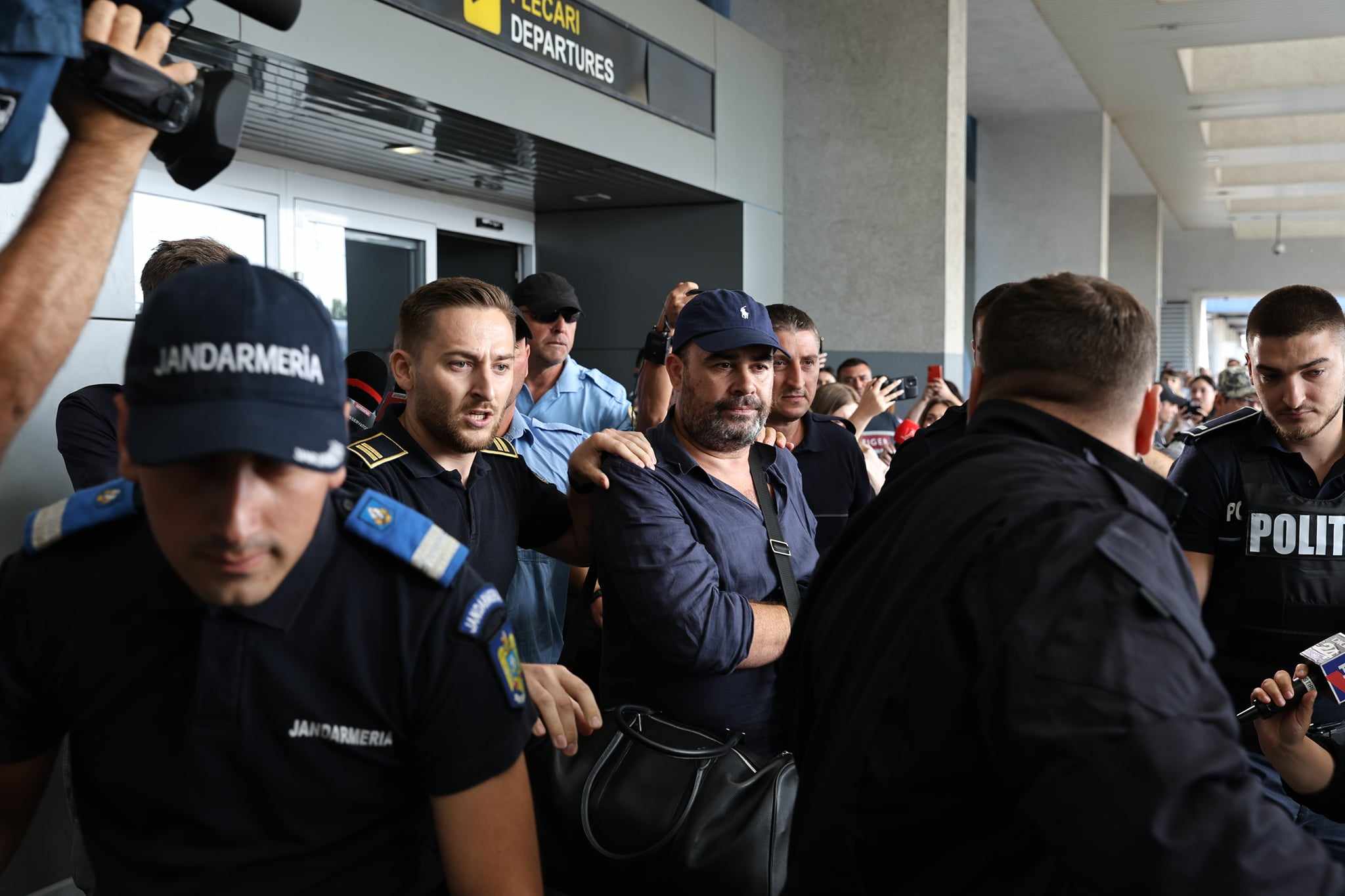 Darius Vâlcov, extrădat din Italia: flancat de jandarmi pe Otopeni, până la mașina care l-a dus la penitenciar. Are de ispășit o pedeapsă de 6 ani de închisoare