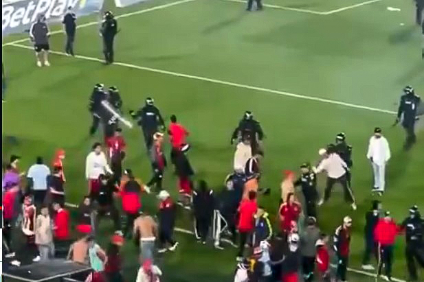 Háború a futballpályán: botokkal, székekkel estek egymásnak a szurkolók, a rendőrök rohampajzzsal és könnygázzal oszlattak – videó