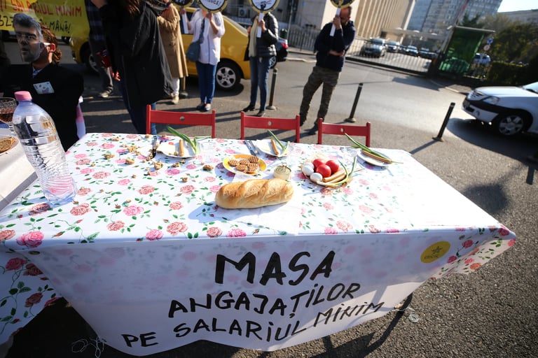 Protest în timpul ședinței de Guvern pe tema salariului minim european. „Ciucă”, „Ciolacu” și „Budăi” au luat masa în Piața Victoriei