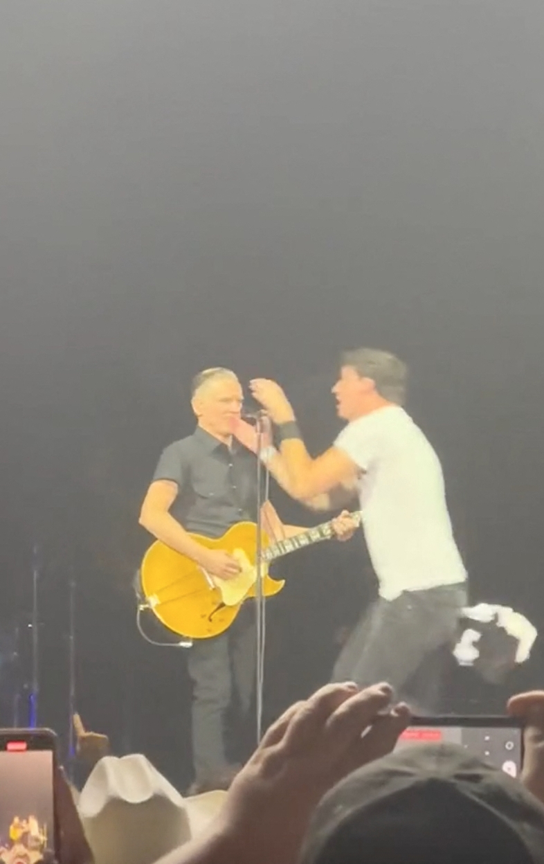 Momentul în care un fan sare pe scenă în timpul concertului lui Bryan Adams, îi smulge microfonul și începe să cânte. Reacția artistului