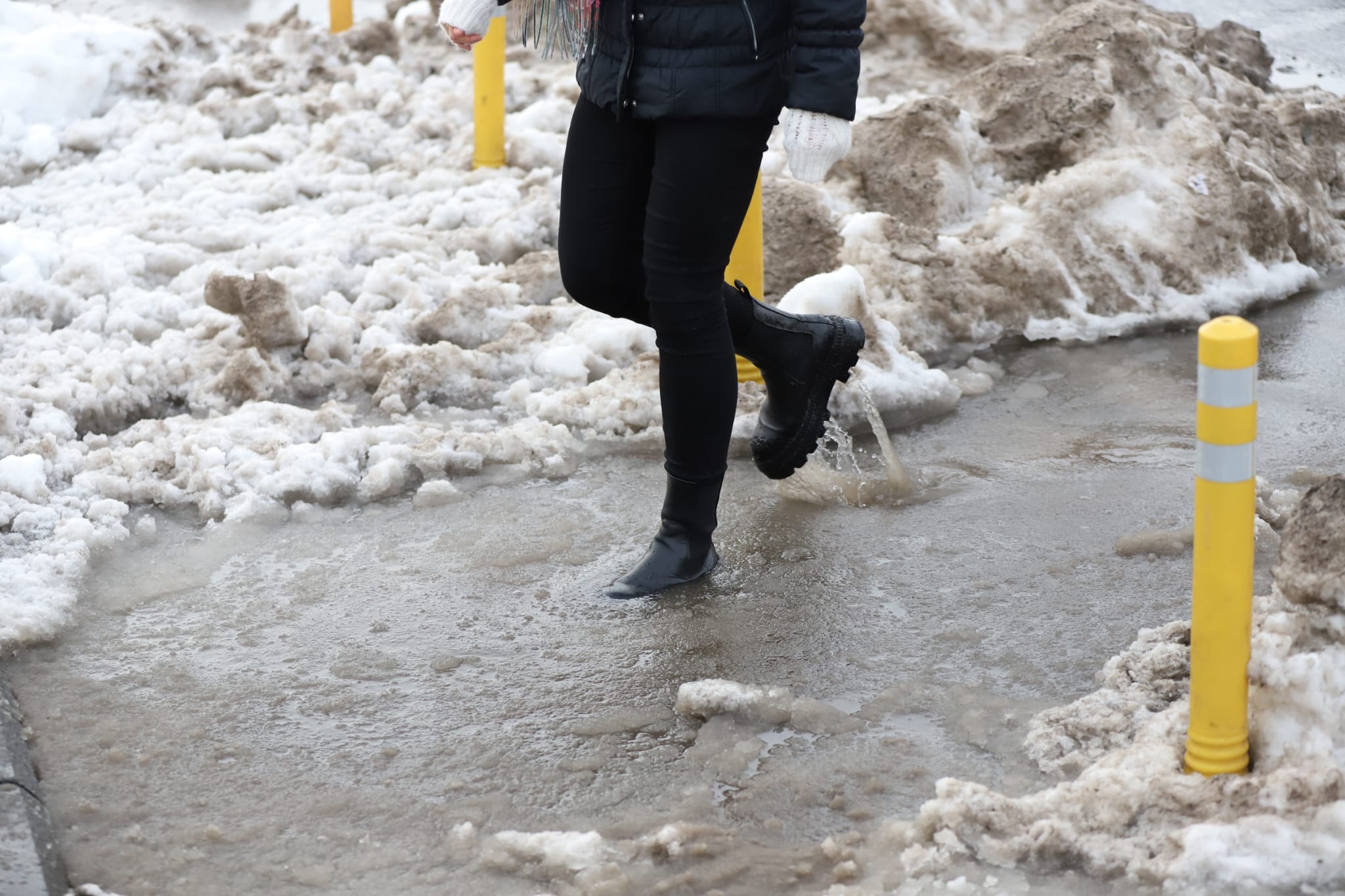 Trotuarele din București, blocate de nămeți și bălți. Oamenii fac slalom printre troiene