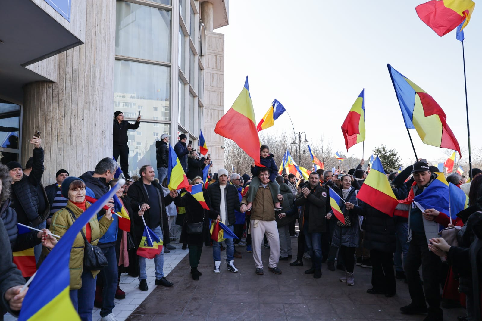 Oameni urcați pe blocuri în București ca să vadă marșul susținătorilor lui Călin Georgescu