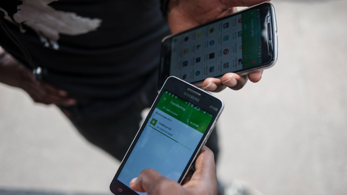 People transfer the Pokémon Go mobile game amounts to each other on the campus of the University of Lagos on July 14, 2016. [Photo by STEFAN HEUNIS/AFP via Getty Images]