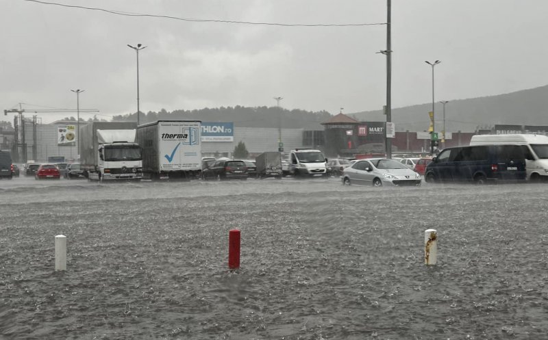 Parcarea unui mall din Cluj, inundată în urma ploii torențiale. Mai multe mașini și persoane au rămas blocate