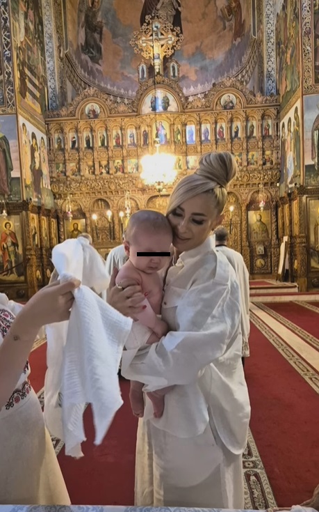 Anamaria Prodan și Ronald Gavril, în postura de nași de botez. Îmbrăcați în alb, au devenit părinții spirituali ai unui băiețel