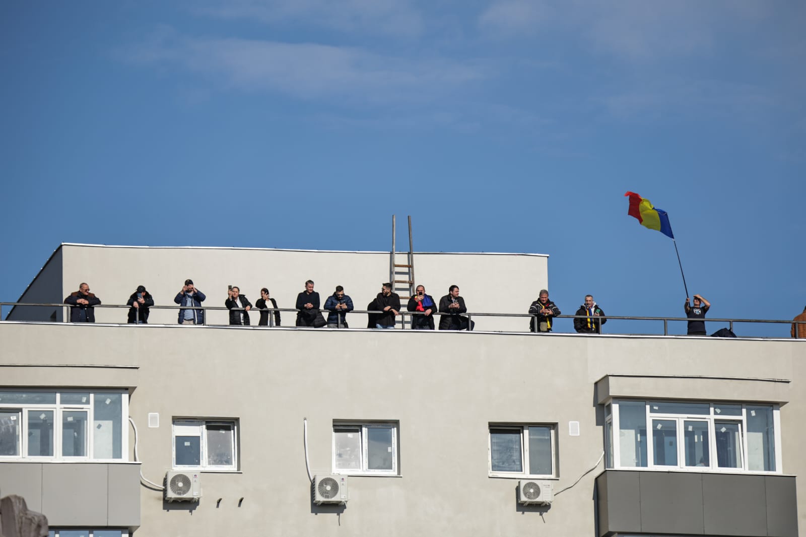 Oameni urcați pe blocuri în București ca să vadă marșul susținătorilor lui Călin Georgescu