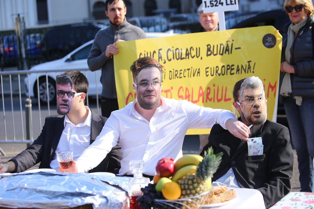 Protest în timpul ședinței de Guvern pe tema salariului minim european. „Ciucă”, „Ciolacu” și „Budăi” au luat masa în Piața Victoriei