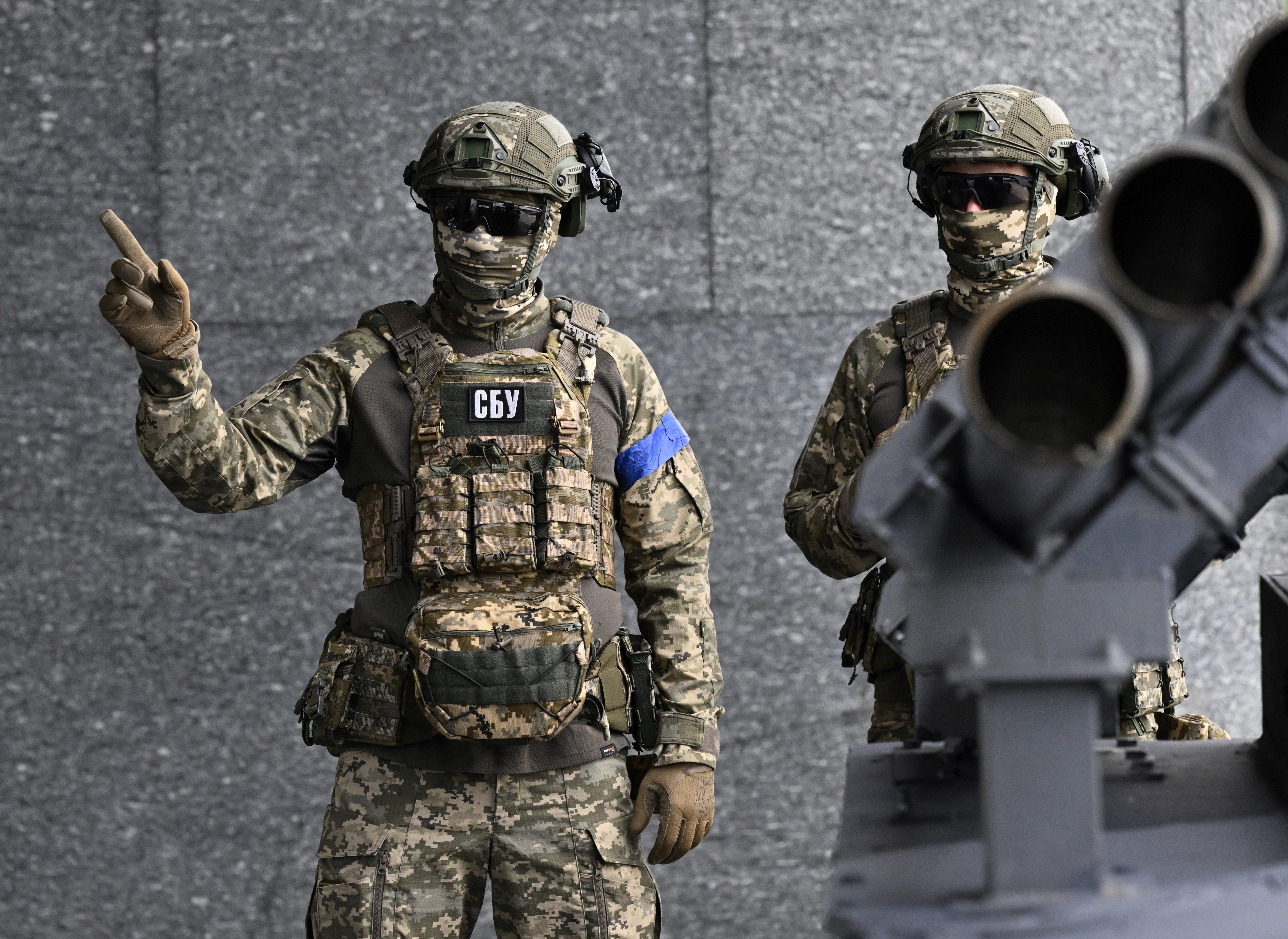 Servicemen of the Security Service of Ukraine stand next to a 
