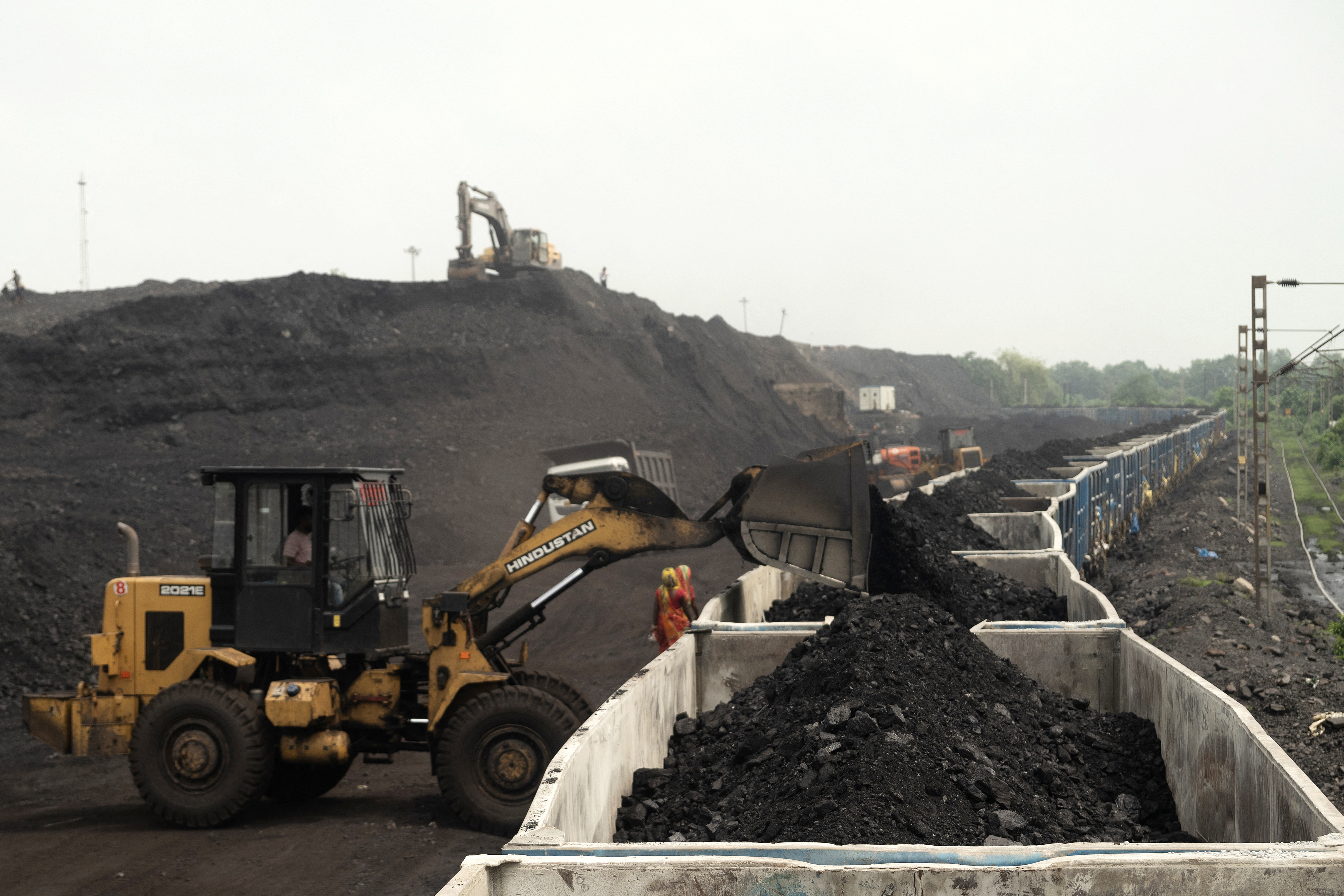 A worker operates a wheel loader to convey heaps of raw coal into train carriages, excavated from an open-cast mine on the outskirts of Dhanbad, in India's Jharkhand state on August 13, 2025. [Photo by Vishal kumar singh / AFP via Getty Images]
