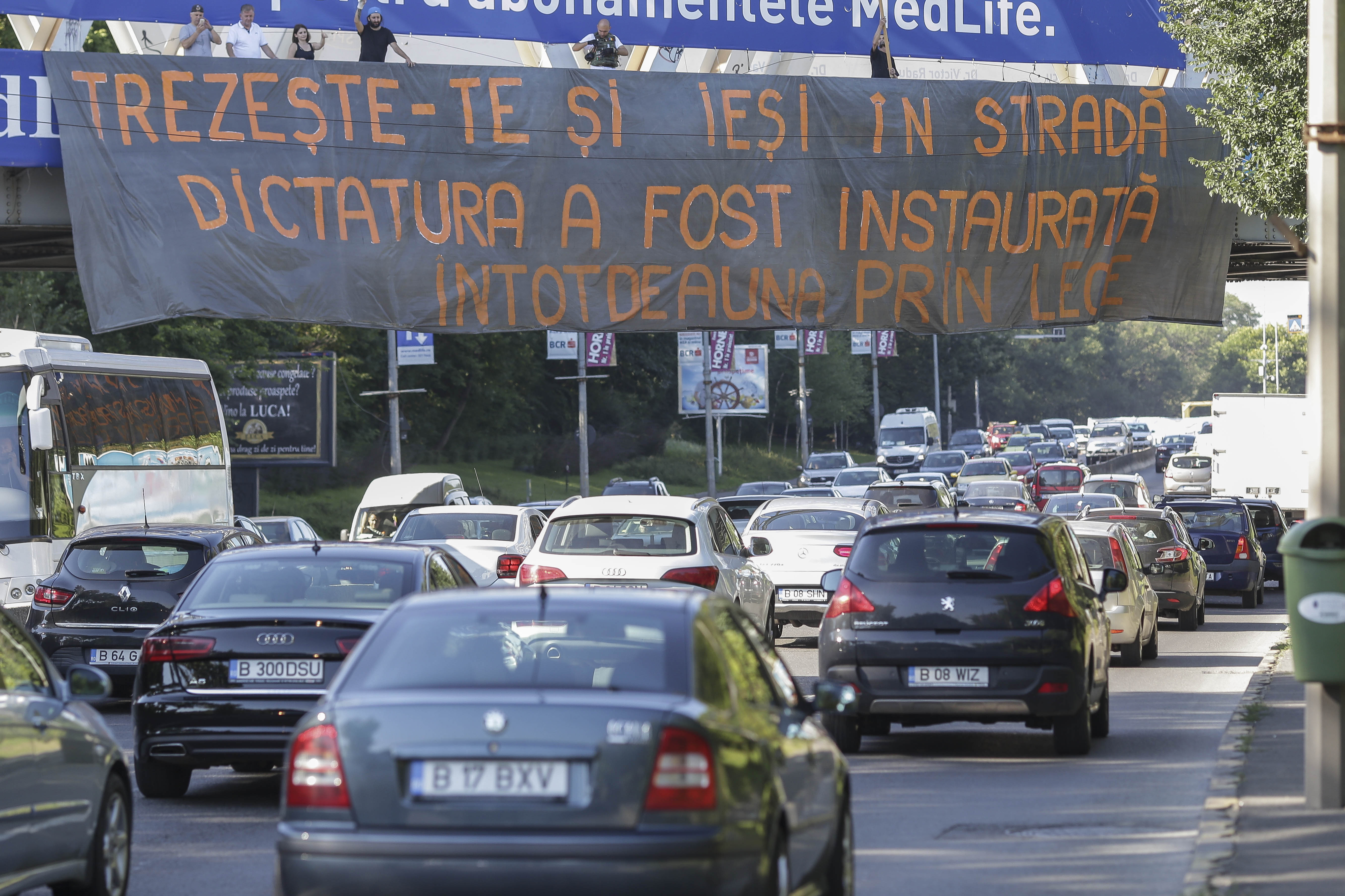 FOTO / Acţiuni împotriva OUG privind amnistia şi graţierea, în Capitală. Banner pe podul de la Fântâna Morița și incidente în Piața Victoriei