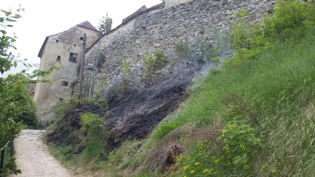 Incendiu de vegetaţie uscată lângă zidurile Cetății Râşnov. Pompierii au stins focul după o oră/ FOTO