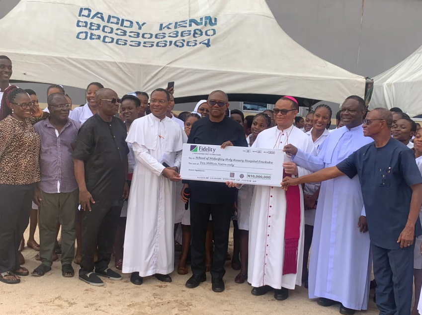 The LP Presidential Candidate in the 2023 General Elections, Mr Peter Obi, sandwiched by two priests, while presenting a cheque for N10 million donation to the Holy Rosary College of Nursing, Emekuku, Owerri, on Saturday [NAN]