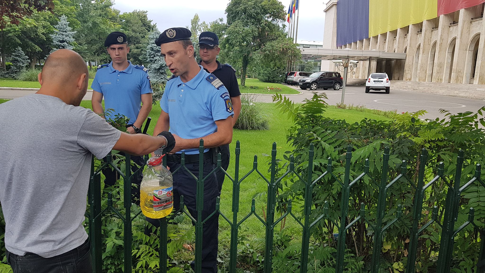 UPDATE. Bărbatul care s-a legat cu lanțul de gardul Guvernului și avea asupra lui o sticlă de benzină a fost descarcerat si ridicat de Jandarmerie (FOTO / VIDEO)