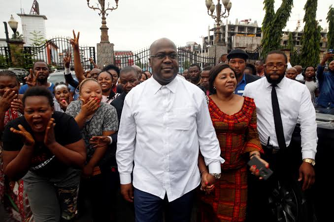 DRC President Félix Tshisekedi walks with his wife, Denise Nyakeru, and gestures to supporters after being declared the winner of the presidential election in Kinshasa. Photo credit: Reuters: Olivia Acland/Baz Ratner
