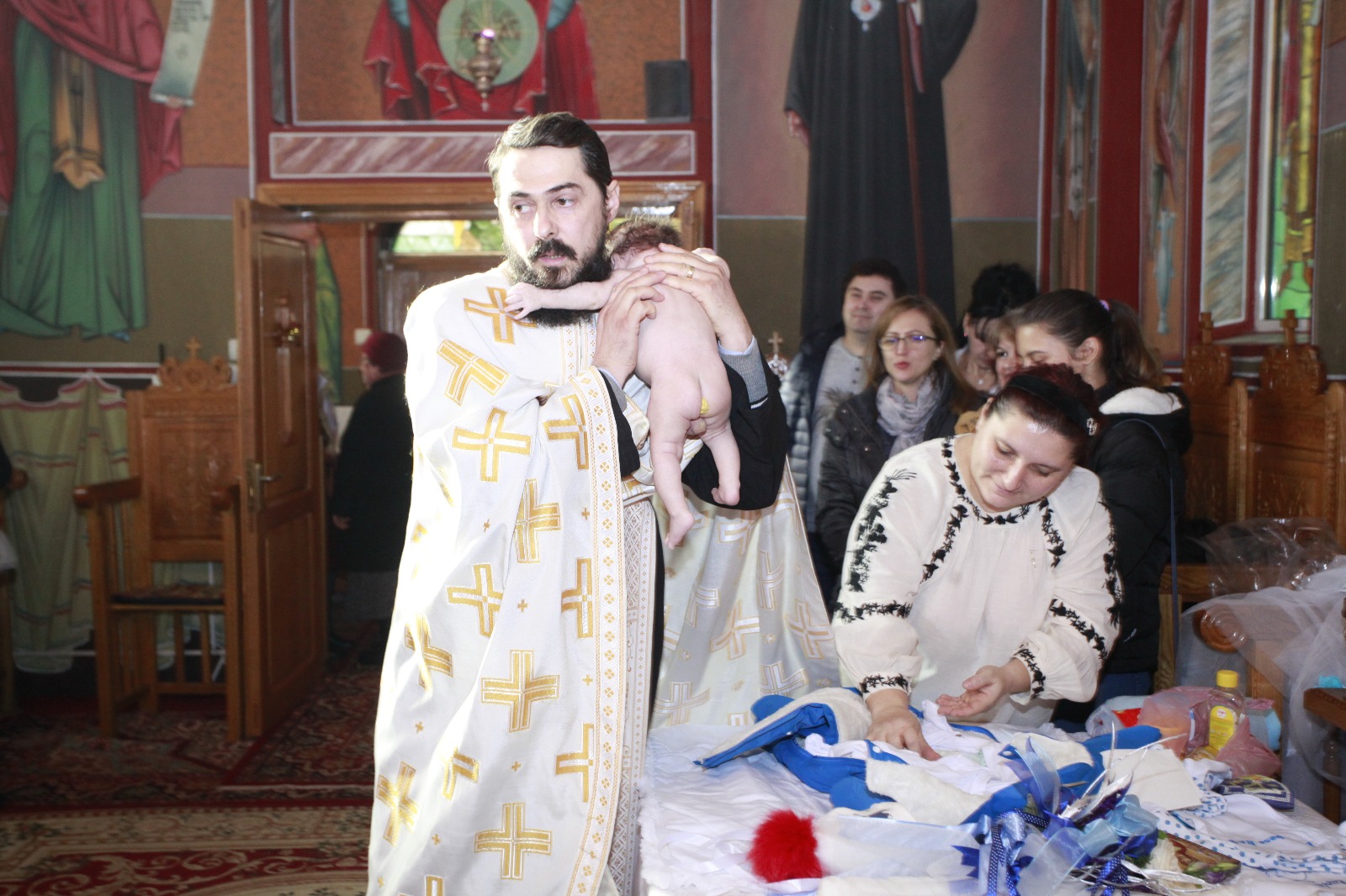 FOTO-REPORTAJ: Abandonat de mamă, s-a ales cu zeci de părinți spirituali. Bebelușul lăsat în ger a fost botezat