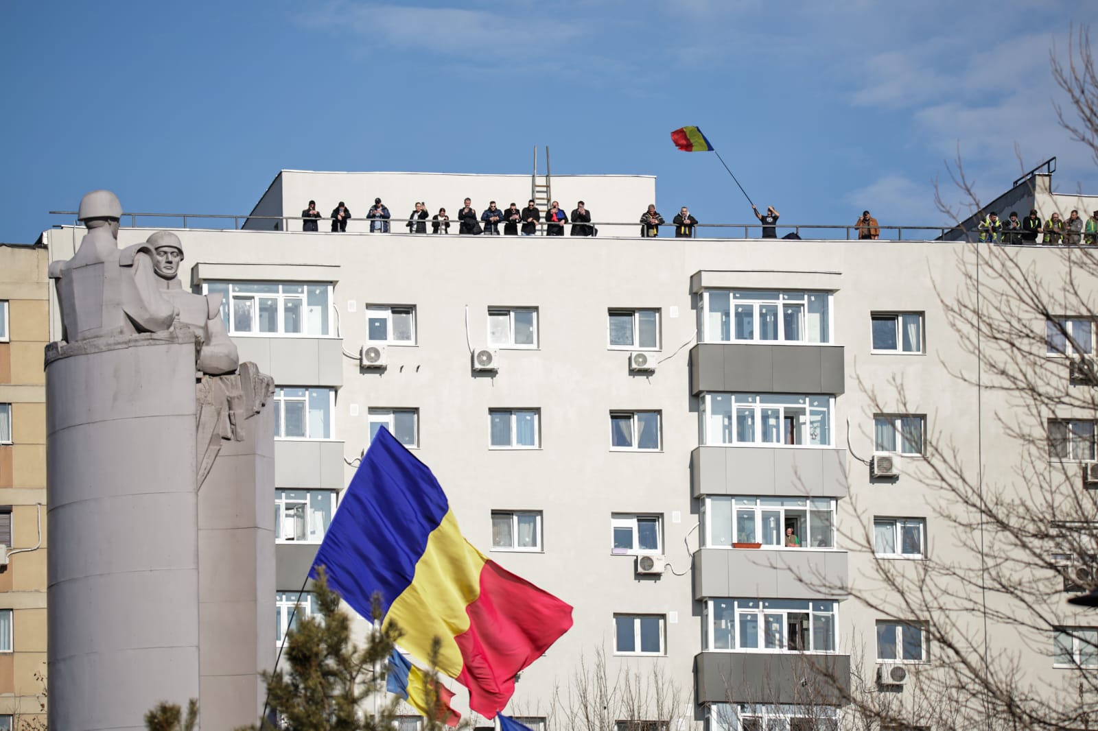 Oameni urcați pe blocuri în București ca să vadă marșul susținătorilor lui Călin Georgescu