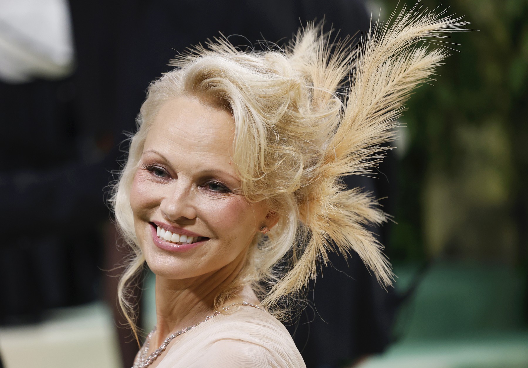 Pamela Anderson, diva de la Met Gala 2024. A încercat să respecte codul vestimentar și și-a înfrumusețat cocul cu pene