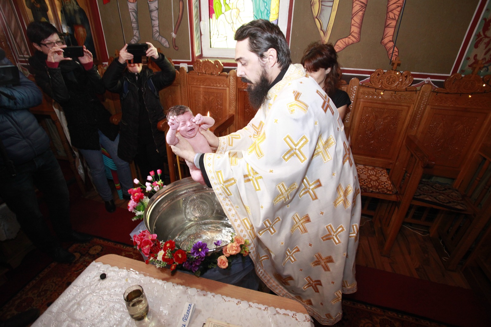 FOTO-REPORTAJ: Abandonat de mamă, s-a ales cu zeci de părinți spirituali. Bebelușul lăsat în ger a fost botezat