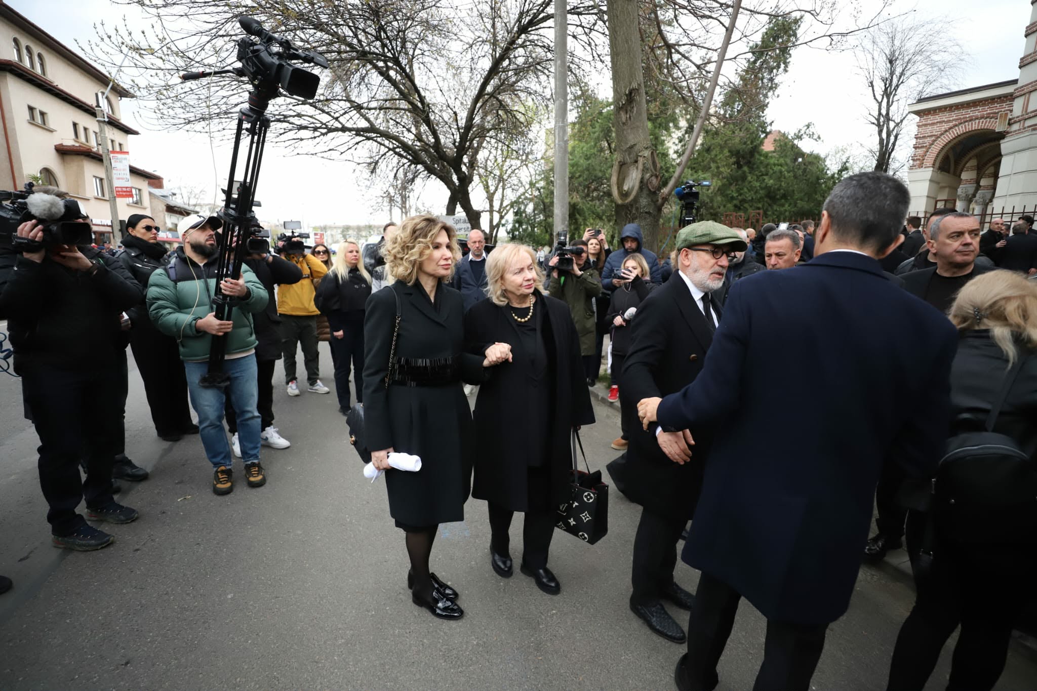 Imagini sfâșietoare la înmormântarea lui Mircea Lucescu. Neli Lucescu, ținută strâns de mână de fiu și sprijinită de noră