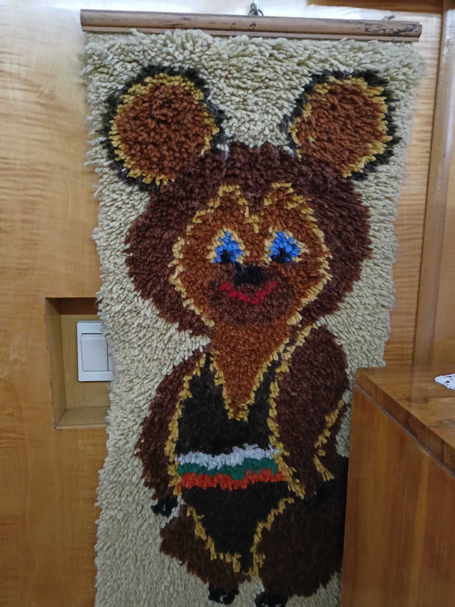 Oficjalna maskotka Letnich Igrzysk Olimpijskich 1980 w Moskwie, przedstawiająca uśmiechniętego brunatnego niedźwiadka o imieniu Misza - w formie makatki na ścianę
