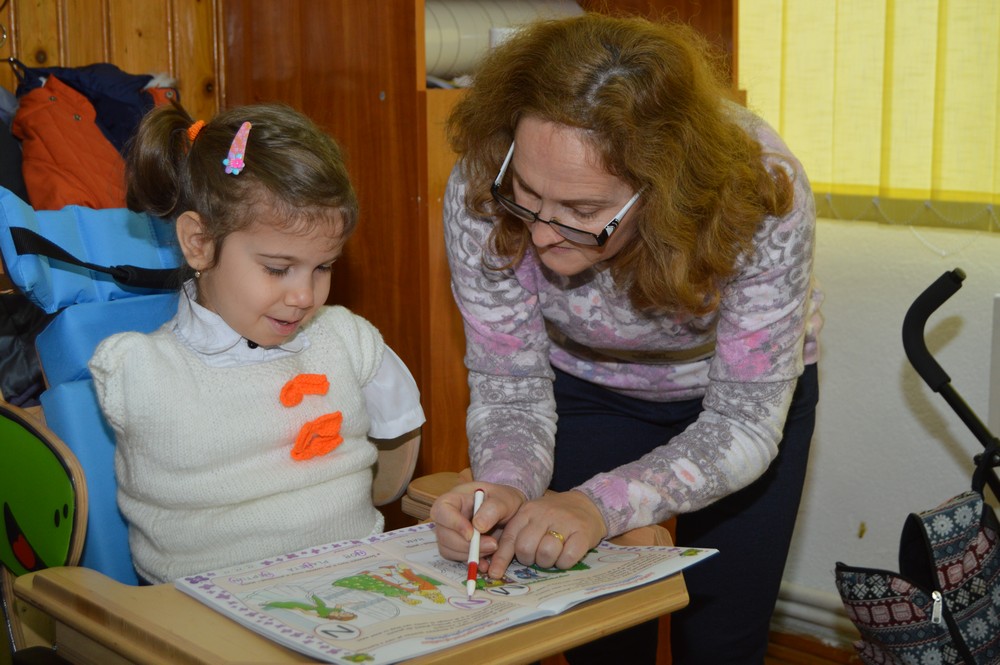 EXCLUSIV/ Delia, fetița care în pofida handicapului grav merge la o școală obișnuită, s-a integrat bine în colectiv: "Îmi place mult la școală"/FOTO