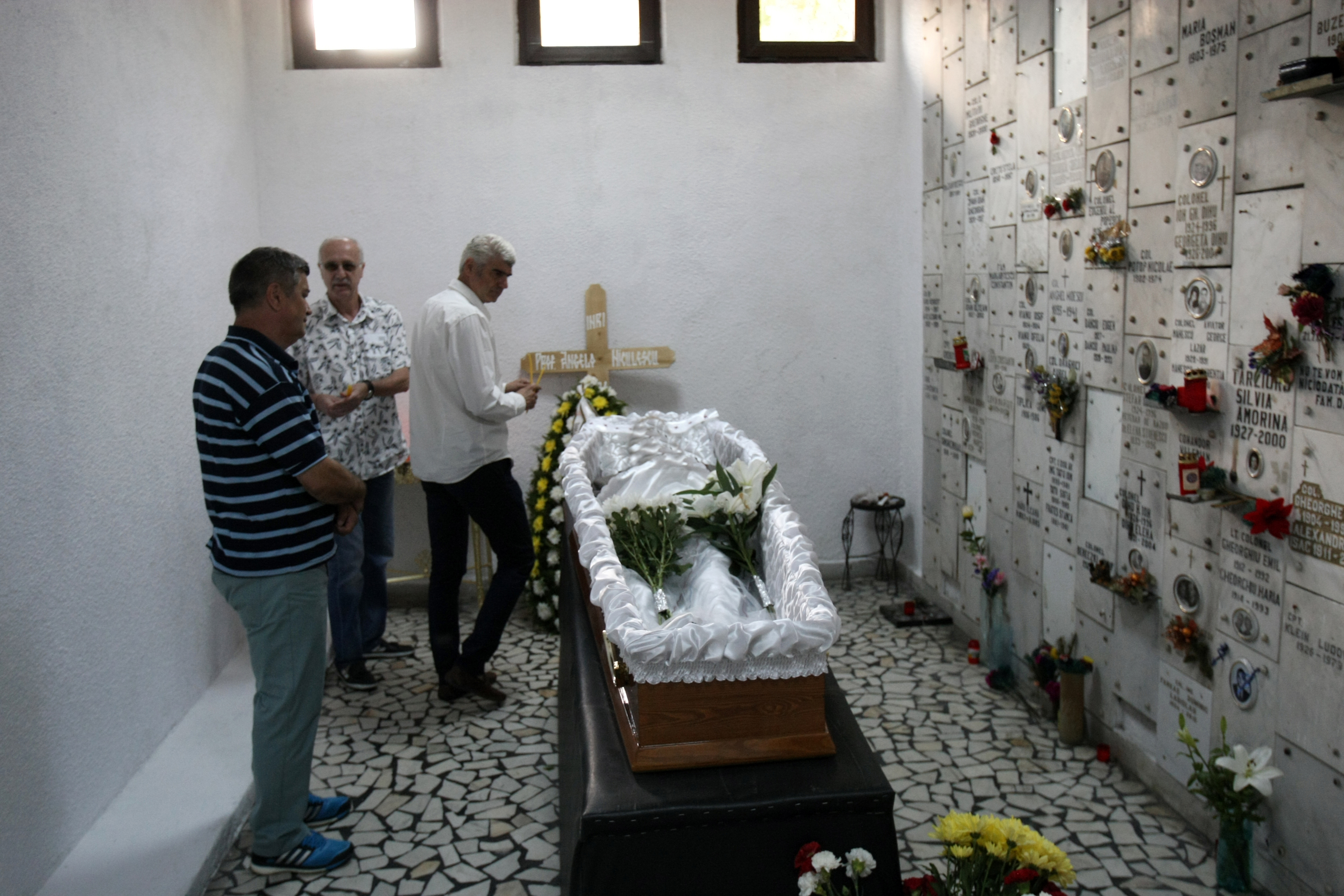 Trei coroane, flori și puține lumânări la mormântul lui nea Angelo